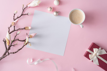 White and pink flowers on pastel pink background with paper card note. Minimal flat lay top view composition.