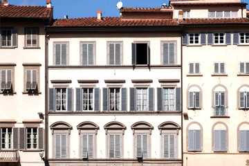 Facade of historical italian city, Tuscany. Windows with shutters of old houses in Italy