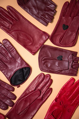background of a variety of burgundy gloves on beige