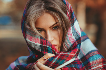 Fototapeta premium Portrait of a beautiful blonde with a scarf in the park