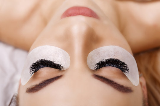 Eyelash Extension Procedure. Woman Eye with Long Eyelashes. Close up, selective focus. Hollywood, russian volume