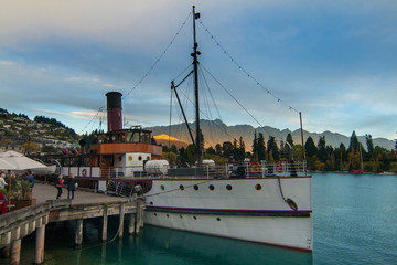 Sunset in Queenstown wharf with steamship attraction on lake Wakatipu, the famous vintage twin screw steamer and The Remarkables mountains on background, New Zealand, South Island