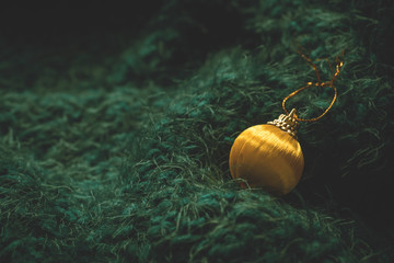 Christmas toy. Yellow Christmas ball on a soft green background. Christmas holiday celebration concept