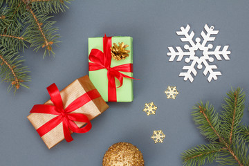 Gift boxes, fir tree branches and christmas toys on gray background