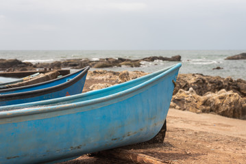 Fototapeta na wymiar Fishing boat docked on a rocky shore in Vagator Goa