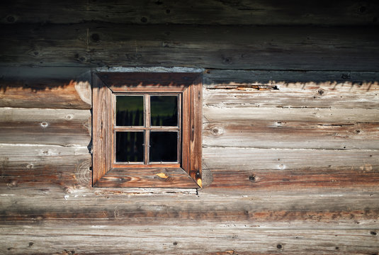 Wooden window in the old textured vintage wood logs wall background.