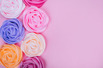 Beautiful pink, magenta, orange and violet rose flower shaped meringue flatlay.