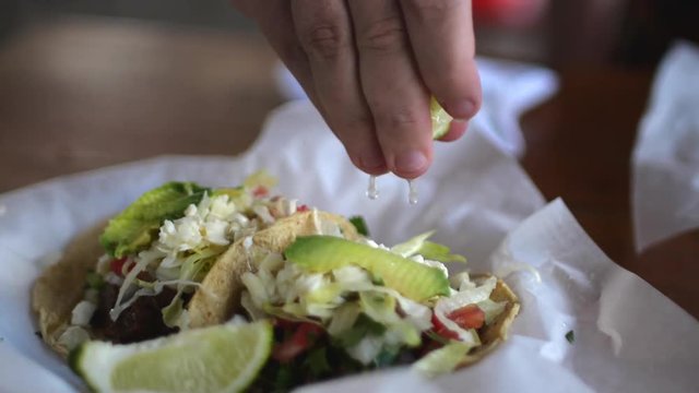 Closeup of squeezing lime on traditional tacos