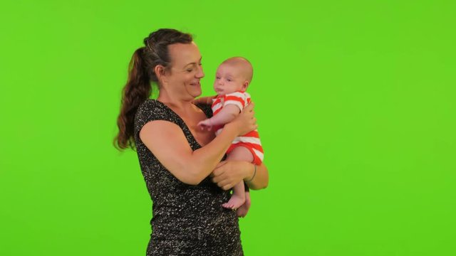 A cute Newborn baby boy and his mom over a green screen.