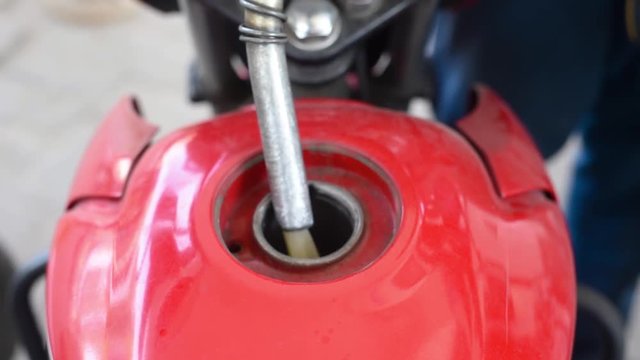Motorbike is filled up with petrol at a petrol station in India