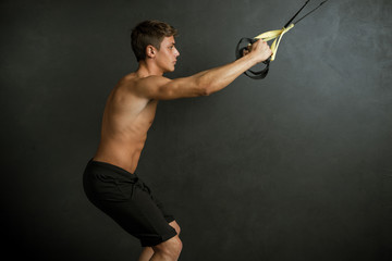 Young boy performing physical exercises on black background