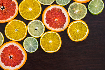 Fototapeta na wymiar Citrus fruit cut in half - oranges, lemons, lime, tangerines, grapefruit on a wooden background