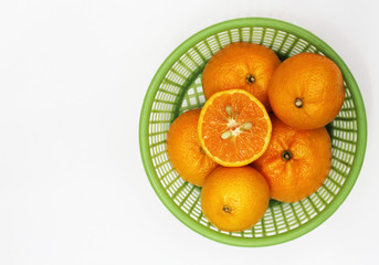 Orange is in a green basket. The fruit is sweet and has high vitamin C.