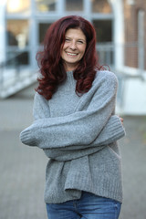 Fototapeta premium Ältere rothaarige Frau mit Pullover lacht