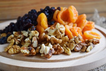 Useful dried fruits and walnuts on wooden background and burlap.