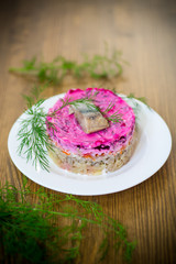 layered salad of boiled vegetables with beets and herring