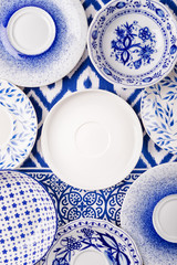 Set of blue and white dishes on a blue and white kitchen towel. Top view, copy space