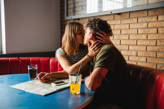 Young couple kissing while sitting in cafe