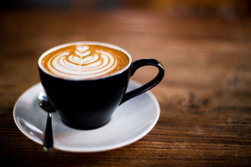Cup of tasty cappuccino on wooden background