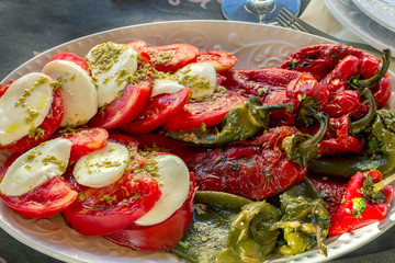 Fresh seasonal salad. Caprese and roasted peppers the salad, seasoned with salt and olive oil.