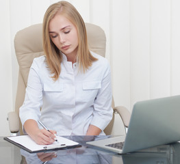 Woman sitting at doctor room and writing diagnosis.