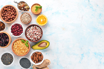 Healthy food. Superfoods Nuts, berries, fruits, and legumes. On a white stone background. Top view. Free copy space.