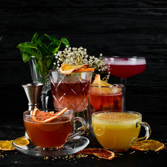 A selection of hot cocktails. Winter drinks. Hot wine. On a black wooden background. Top view. Free copy space.