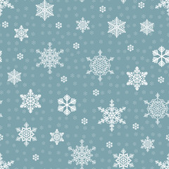 Seamless scattered white snowflakes and small pale blue snowflakes pattern on a blue background