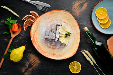 Chocolate Brownies Dessert with Pear. Dessert, pastry. On a wooden background. Top view. Free copy space.