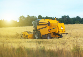 Yellow industrial combine harvester working in the field.