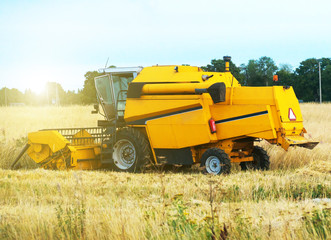 Yellow industrial combine harvester working in the field.