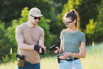 the instructor teaches the girl to shoot a pistol at the range