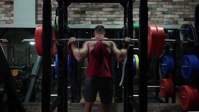 The man going to barbell to do squats