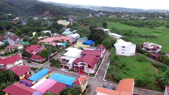 Los Ba&ntilde;os, Laguna, Philippines - November 21, 2017: Modern housing community at the foot of mountain rainforest. Drone Aerial Shot