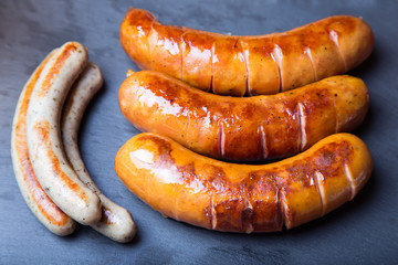 Grilled sausages on black board. Close-up, selective focus.