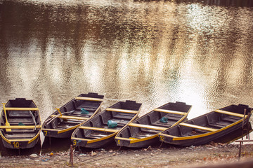 Fototapeta na wymiar fishing boat in a calm lake water/old wooden fishing boat/ wooden fishing boat in a still lake water