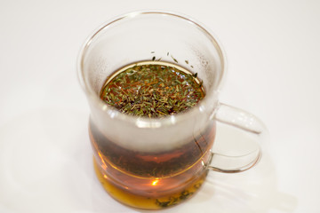 flavored black green tea with grass white background glass