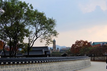 Traditional korean Buildings and walls with a catholic christan church on one picture.