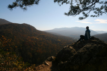 A young woman admires the view from the top of the Plancheskie rocks.