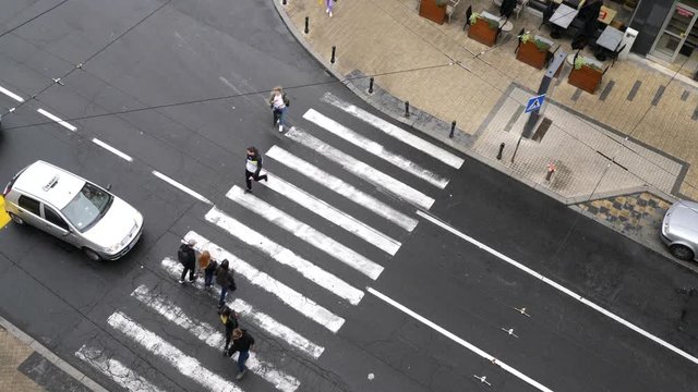 Aerial view on busy street with people and cars across zebra