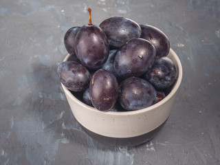 Fresh prunes in a brown beige vase