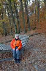 seniorin sitzt auf einer bank im binger wald