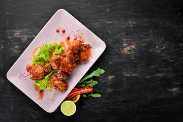 Chicken shish kebab with sesame seeds and barbecue sauce. On a wooden background. Top view. Free space for your text.