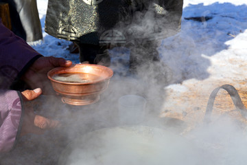 Copper bowl in hand with traditional Mongolian tea