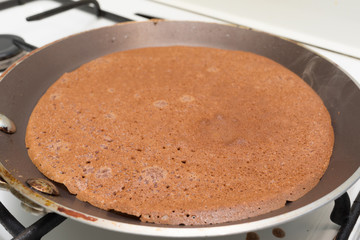 Fried chocolate pancake in a pan