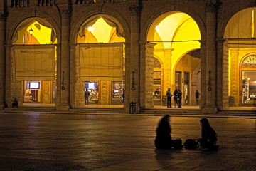 two girls talking in "Maggiore" square in Bologna (IT)