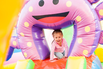 A cheerful child plays in an inflatable castle