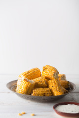 Grilled corn cobs on the white wooden background