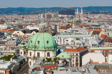 Fototapeta na wymiar Vienna, Austria, September 09,2018: Aerial view of Vienna with tower of the town hall building, votivkirche and peterskirche churches from the stephansdom cathedral.