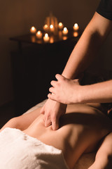 Obraz premium Close-up of male hands. Masseur does massage for the waist of a young girl. Rehabilitation, beauty therapy medicine. healthy concept